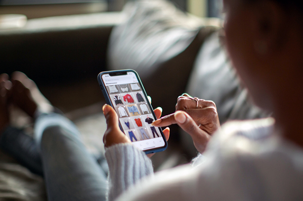 woman looking at clothes online on her phone