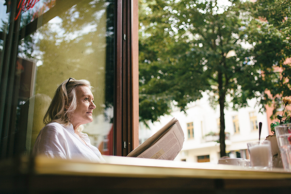 older woman reading newspaper