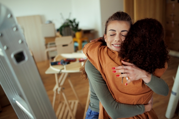 a young woman hugging another woman