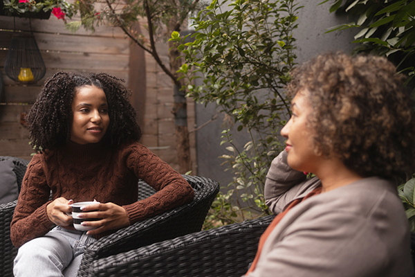 two women chatting on a patio chatting