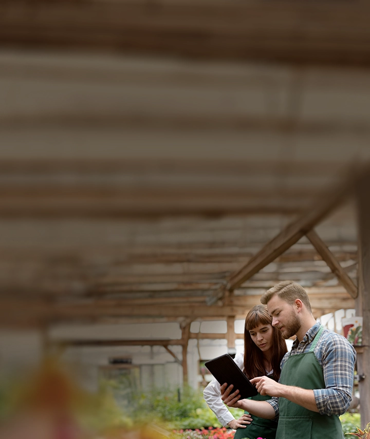 A man and woman having a discussion while looking at a tablet